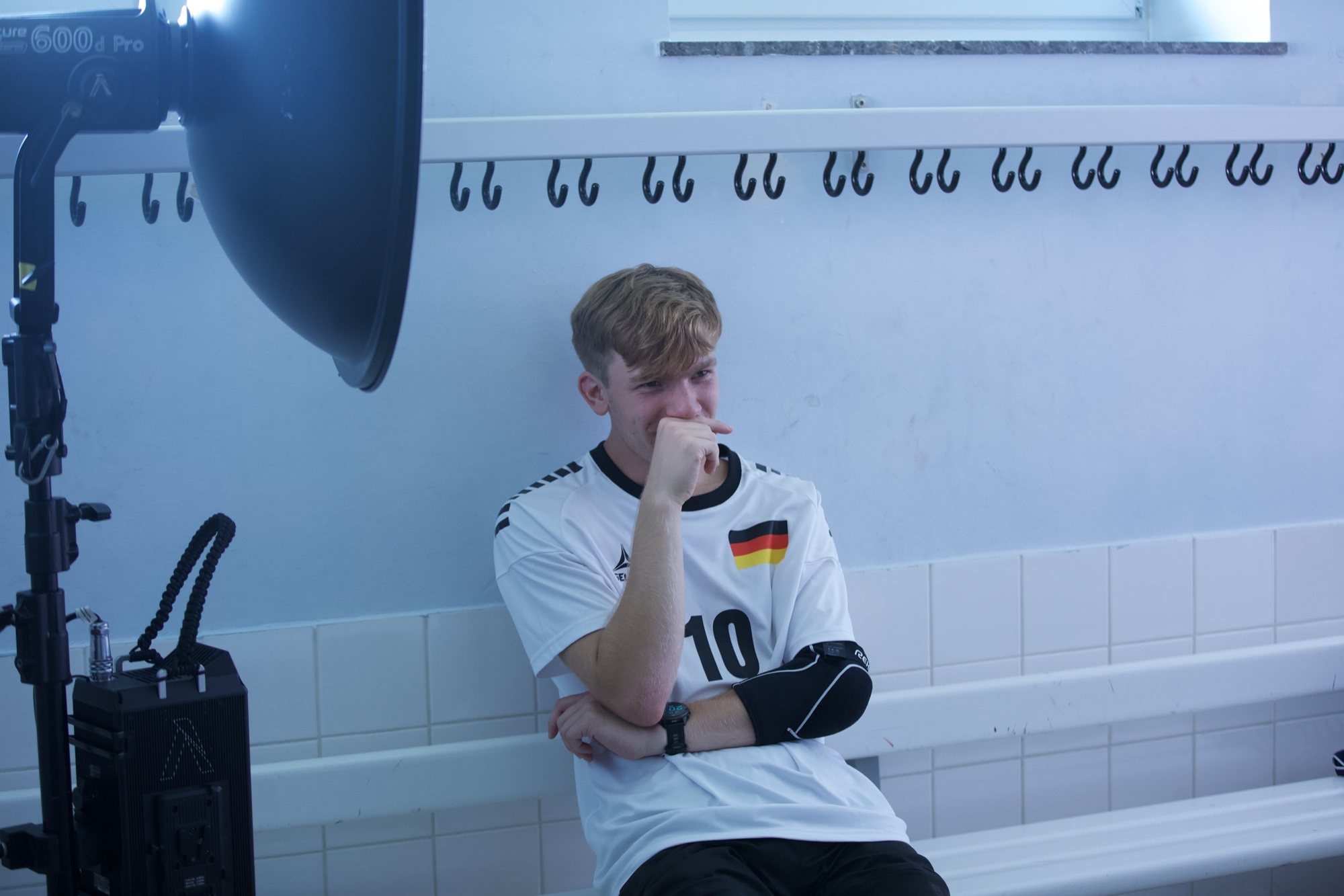 Spieler sitzt nachdenklich auf der Bank in der Umkleide